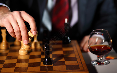 个穿深色西装的商人下棋的形象图片