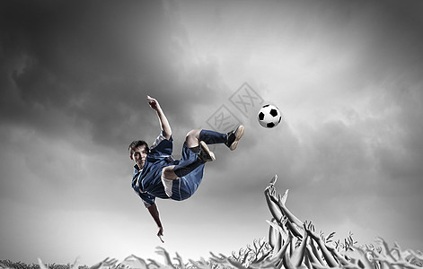足球迷足球运动员跳跃中踢球,由球迷支持图片
