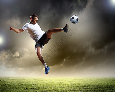 足球运动员足球运动员体育场击球的形象图片