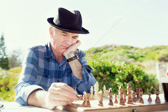 老人坐户外下棋思考国际象棋策略图片