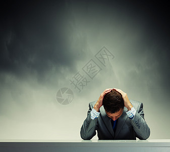 生意上的失败沮丧的轻商人坐雨下湿漉漉的背景