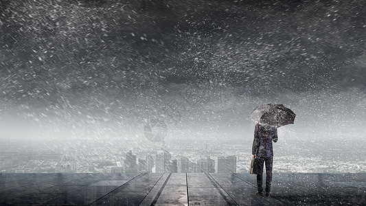 带雨伞的商人带着雨伞的商人的背景看着城市图片