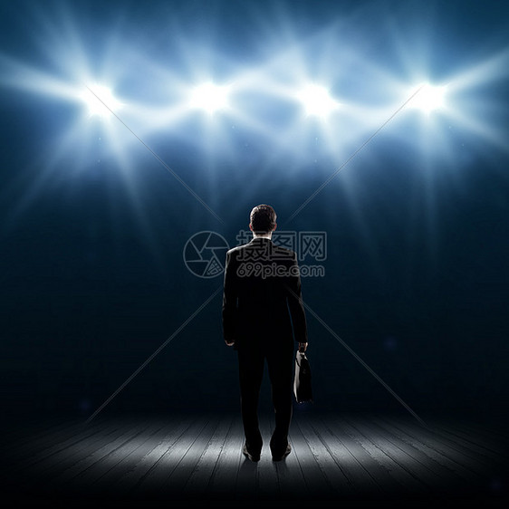 演讲者舞台上站舞台灯光下的商人的后视镜图片