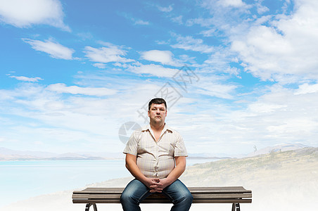 胖子胖子坐长凳上看着镜头图片