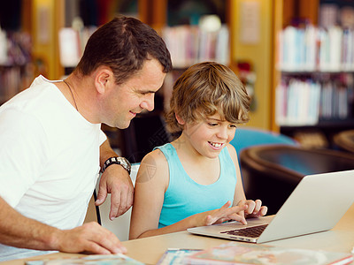 小男孩他父亲图书馆着笔记本电脑小男孩他父亲带着笔记本电脑图片
