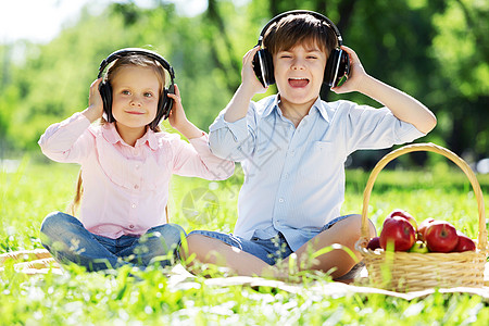 夏天公园里可爱的男孩女孩听音乐暑假周末图片