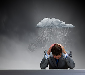 生意上的失败沮丧的轻商人坐雨下湿漉漉的背景