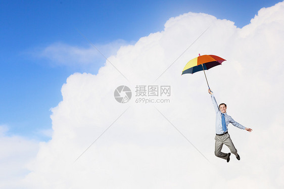 轻的商人伞上高高地飞翔人伞上飞翔图片
