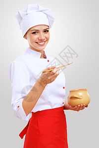厨师的肖像穿着红色围裙的轻女厨师,灰色背景图片