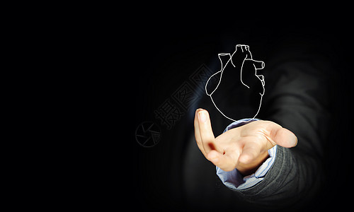 人类的心脏把人的心放手心里的商人的特写图片
