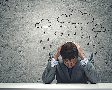 生意上的失败沮丧的轻商人坐雨下湿漉漉的背景