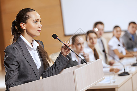 女商人站舞台上为观众报道演讲者舞台上图片