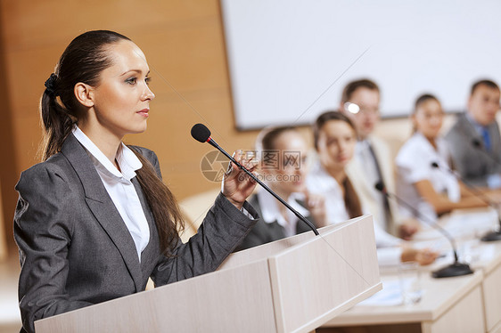 女商人站舞台上为观众报道演讲者舞台上图片