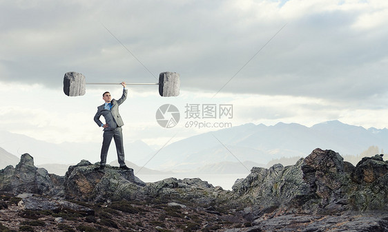 坚强力自信的商人举头顶的石头杠铃图片