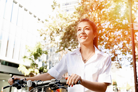 快乐的轻女自行车运动员的肖像城市骑自行车的快乐轻女的肖像图片