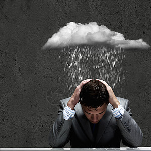 生意上的失败沮丧的轻商人坐雨下湿漉漉的图片素材