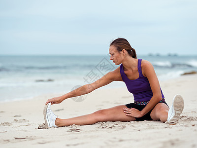 运动的轻女人海边伸展图片