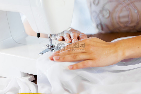 裁缝工作室密切妇女裁缝的手与缝纫机工作图片