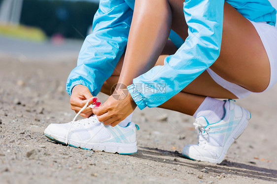 户外跑步轻健康的女孩系运动鞋的鞋带图片