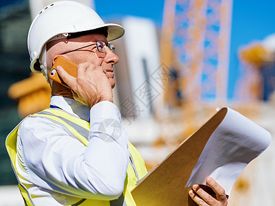 建筑工地的工程师建设者工程师建筑工人施工场景穿着安全背心记事本图片