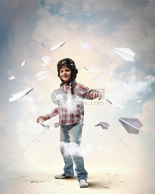 戴着飞行员帽子的小男孩飞行员头盔里的小男孩的形象,背景纸飞机图片