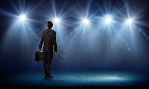 演讲者舞台上站舞台灯光下的商人的后视镜图片