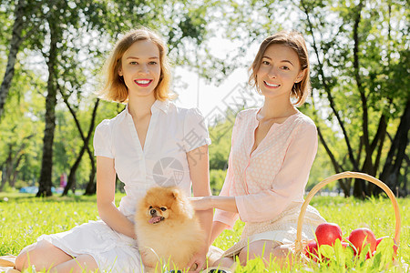 两个漂亮的女士他们可爱的宠物公园里公园里带着可爱的宠物图片