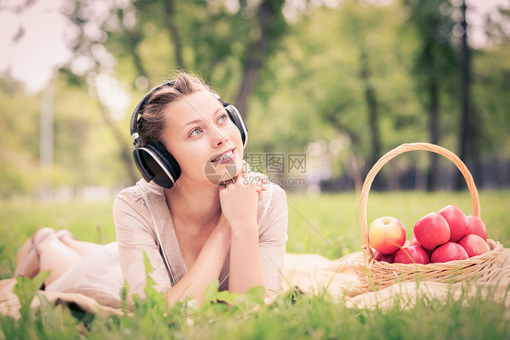 夏天的公园野餐夏天公园里轻迷人的女孩戴着耳机图片