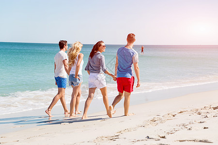 海滩上轻人的陪伴群轻的朋友海滩上沿着海岸散步图片