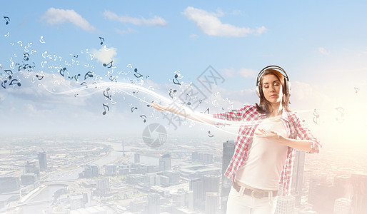 性手势音乐爱好者轻漂亮的女孩穿着休闲的耳机听音乐背景