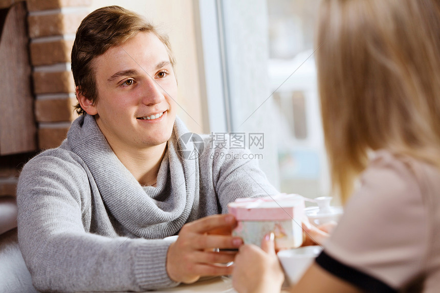 情侣约会约会的轻人给他的女孩送礼物图片