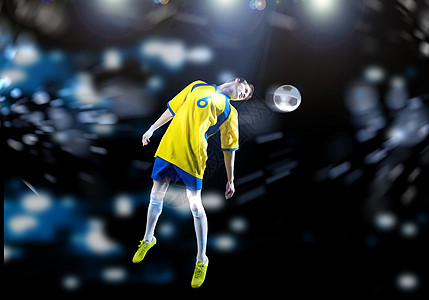 年轻的足球运动员体育场踢皮球,头部跳跃图片
