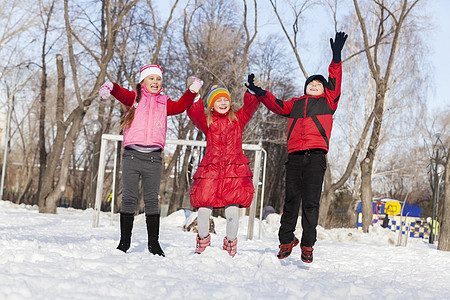 可爱的孩子们在冬天的公园里跳跃玩得开心图片