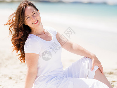 海滩上穿着白色衣服的女人图片