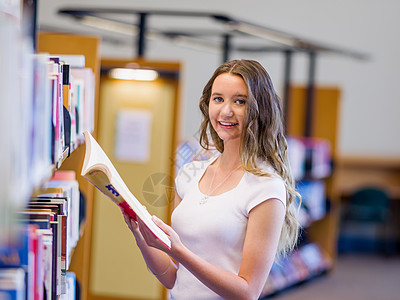 快乐的年轻女学生图书馆选书图片