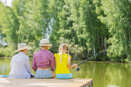 夏季休闲三个孩子坐岸边钓鱼的后视镜图片