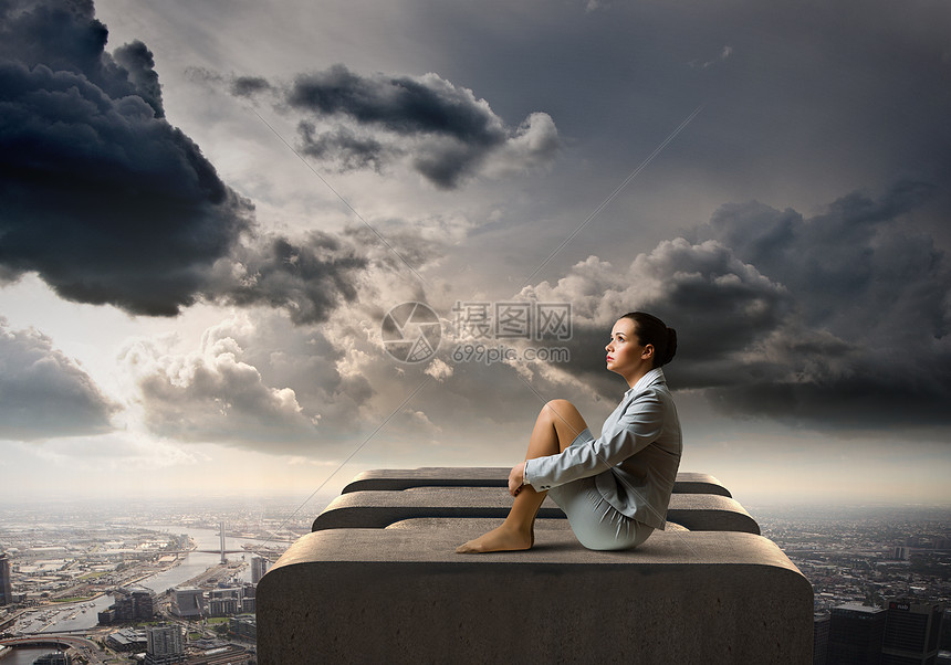 绝望中的女商人轻迷人的女商人独自坐大楼顶上的形象