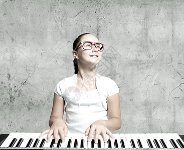 戴着滑稽眼镜弹钢琴的漂亮女孩图片