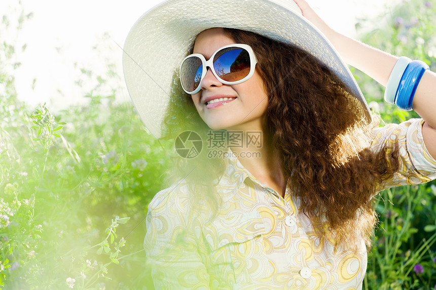 戴帽子的女孩戴着帽子眼镜坐草地上的轻漂亮女孩图片