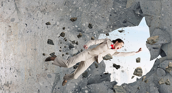 她没障碍情绪化的女商人用空手道拳打破石墙图片素材