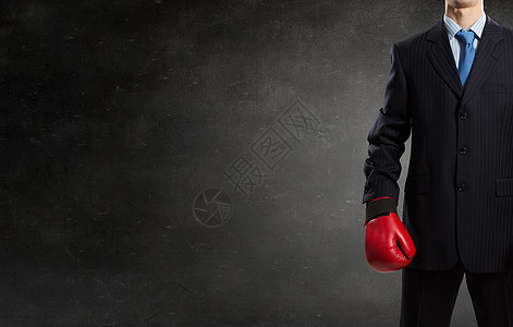 戴拳击手套的商人拳击手水泥背景上戴着红色拳击手套的轻商人图片