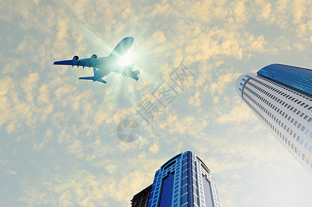 飞机飞过天空城市上空的飞机飞过摩天大楼背景