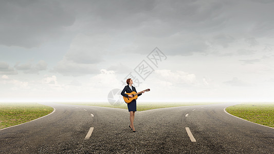 开朗的女商人站路上弹吉他演奏成功的旋律图片