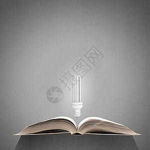 明亮的教育之光打开书发光灯泡以上的页图片