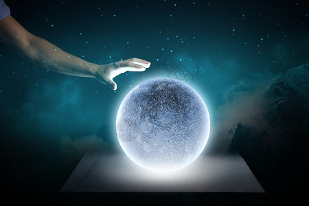 蓝色的月亮靠近人的手触摸蓝色发光的月亮图片