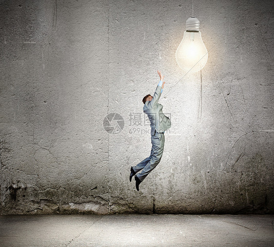 商业理念商人跳跃捕捉灯泡的形象图片