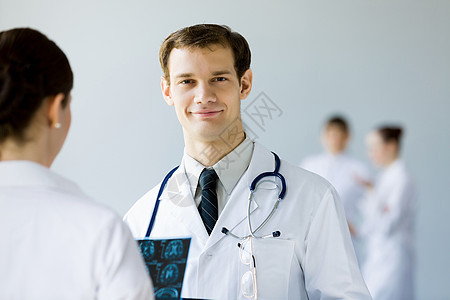 轻的男医生穿着白色制服图片