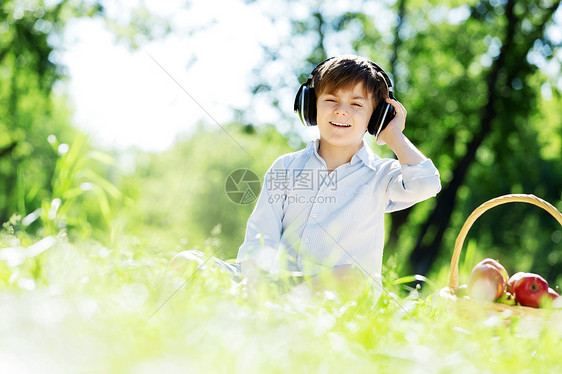 夏天公园里的小快乐男孩戴着耳机大自然的声音图片