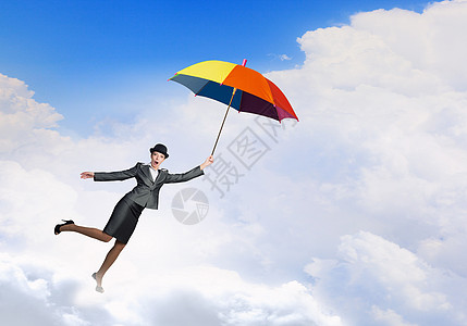 女人伞上飞行穿着西装戴着五颜六色的雨伞的轻女商人图片