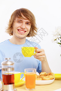 年轻快乐的男人在家喝茶图片